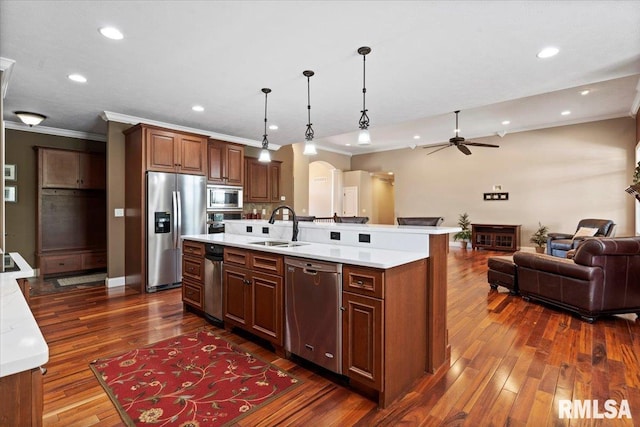 4408 Foxhall Ln, Springfield, IL 62711 - kitchen featuring stainless steel appliances, light countertops, a kitchen island with sink, crown molding, and dark wood-style floors