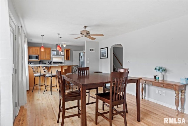 14 Beachview Ln, Springfield, IL 62712 - dining area featuring arched walkways, light wood-style floors, and a ceiling fan