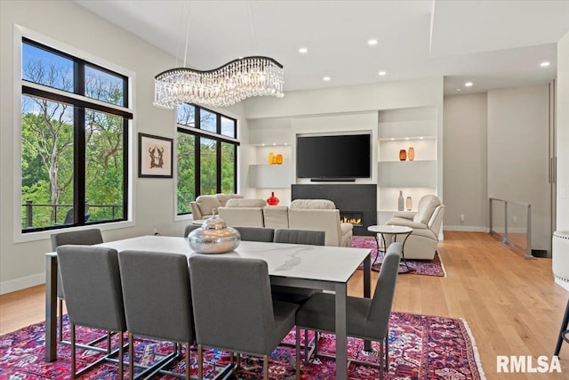 2004 Grants Pond, Chatham, IL 62629 - dining space featuring light wood-type flooring, a chandelier, recessed lighting, and a lit fireplace