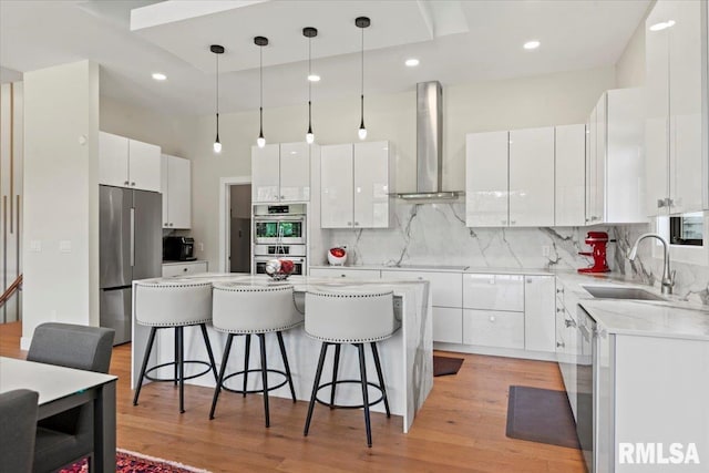 2004 Grants Pond, Chatham, IL 62629 - kitchen with appliances with stainless steel finishes, wall chimney range hood, a kitchen bar, a kitchen island, and white cabinetry