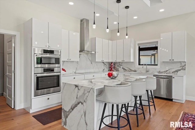 2004 Grants Pond, Chatham, IL 62629 - kitchen featuring stainless steel appliances, wall chimney exhaust hood, light wood-type flooring, a kitchen breakfast bar, and recessed lighting