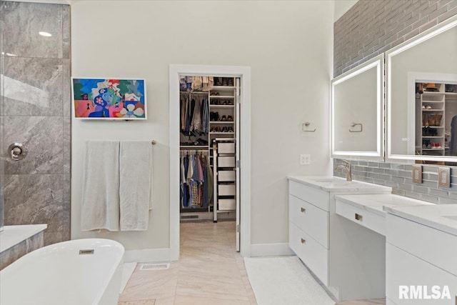 2004 Grants Pond, Chatham, IL 62629 - full bathroom featuring a soaking tub, a walk in closet, double vanity, marble finish flooring, and backsplash