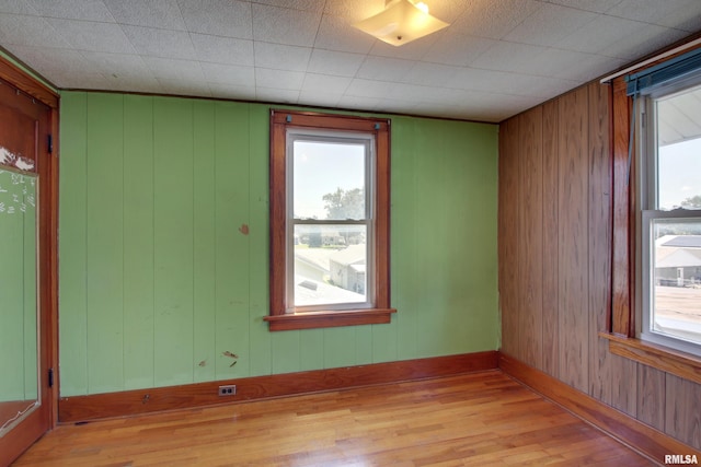 2716 Elm St, Quincy, IL 62301 - empty room with light wood finished floors, healthy amount of natural light, and wooden walls
