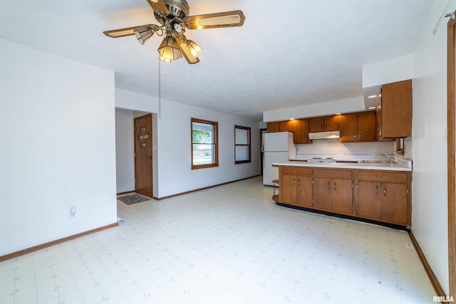 2700 Northridge Dr, Quincy, IL 62301 - kitchen featuring freestanding refrigerator, light countertops, under cabinet range hood, light floors, and brown cabinets