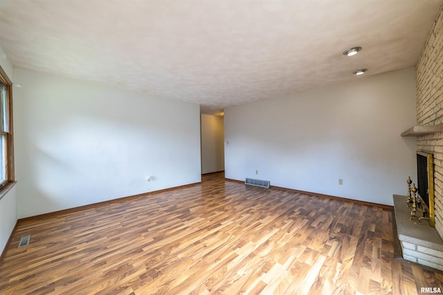 2700 Northridge Dr, Quincy, IL 62301 - unfurnished living room with wood finished floors and a brick fireplace