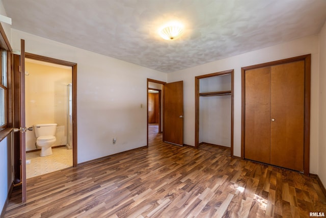 2700 Northridge Dr, Quincy, IL 62301 - unfurnished bedroom featuring two closets, wood finished floors, and ensuite bath