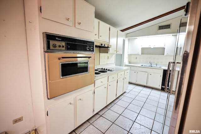 29498 420th St, Griggsville, IL 62340 - kitchen with white appliances, under cabinet range hood, vaulted ceiling, light countertops, and light tile patterned flooring
