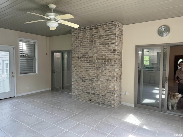 4004 Abbey Ridge St, Quincy, IL 62305 - spare room featuring light tile patterned floors, brick wall, and a ceiling fan