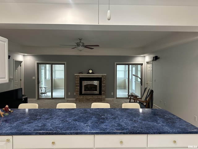4004 Abbey Ridge St, Quincy, IL 62305 - kitchen with a ceiling fan, a fireplace, white cabinetry, and carpet