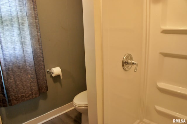 bathroom with hardwood / wood-style flooring and toilet