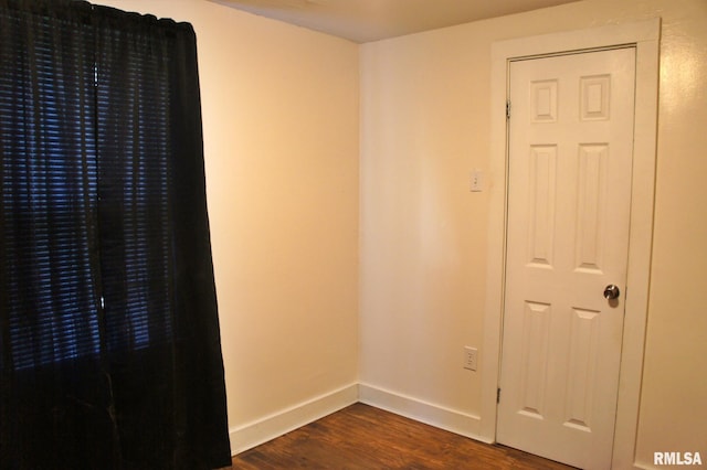 empty room with dark hardwood / wood-style flooring