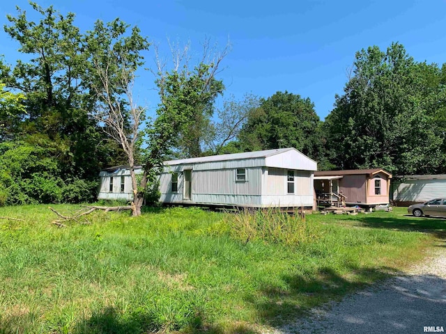 view of front facade with an outdoor structure and a front yard