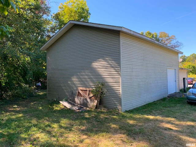 view of side of home with a yard and a garage