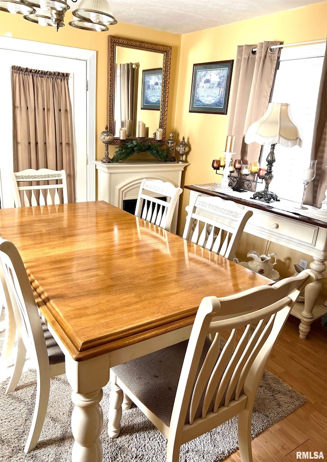 dining area with hardwood / wood-style floors and a chandelier