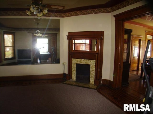 unfurnished living room featuring ceiling fan and dark carpet