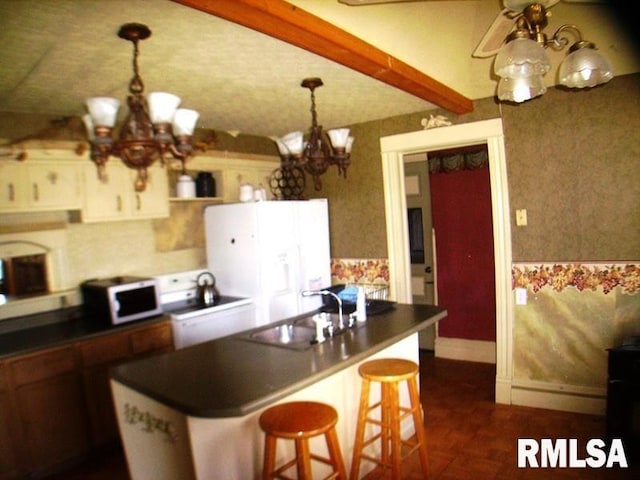 kitchen with an inviting chandelier, a breakfast bar, sink, and beamed ceiling