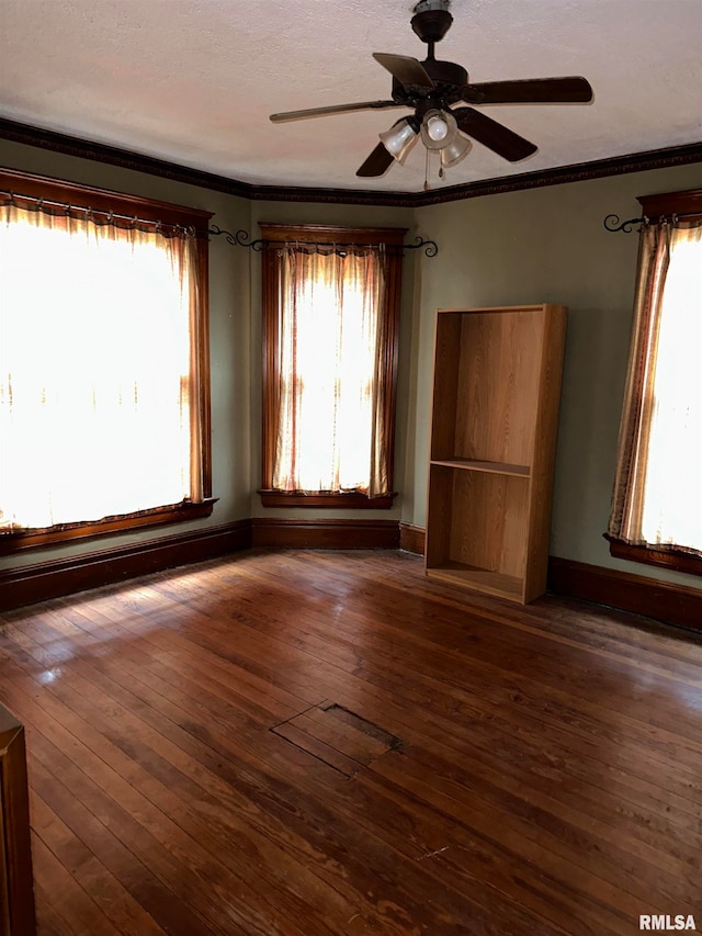 interior space featuring ceiling fan, crown molding, and dark wood-type flooring