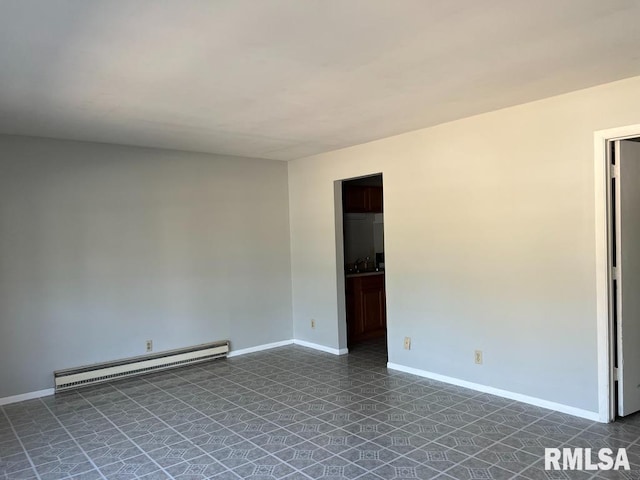 tiled spare room featuring a baseboard radiator