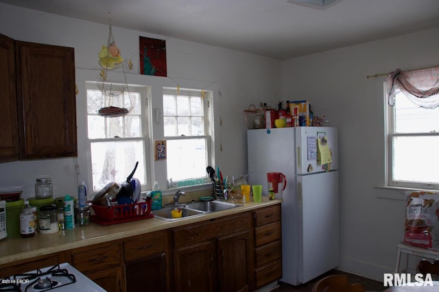 kitchen with plenty of natural light, white appliances, and sink