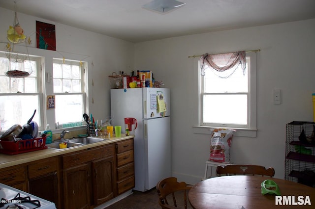 kitchen with stove, sink, and white fridge