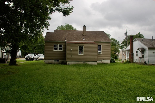 rear view of house featuring a yard