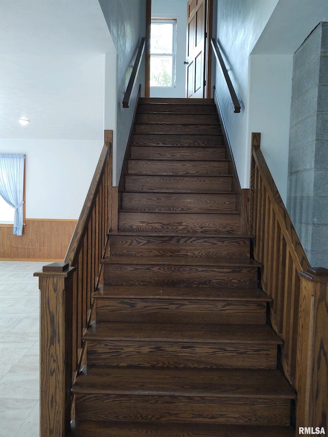 staircase with dark tile floors