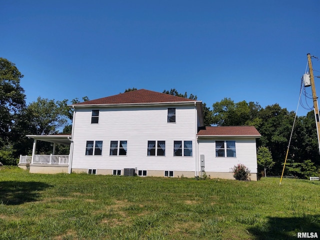 back of property featuring central AC and a lawn