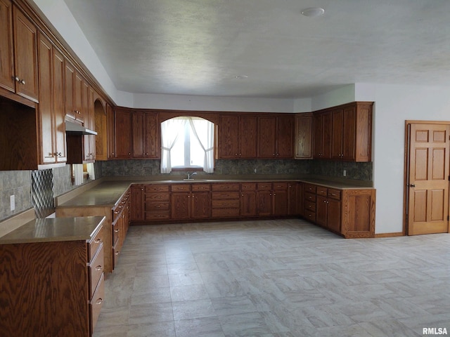 kitchen with backsplash, light tile floors, and sink