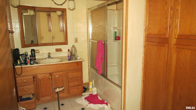 bathroom with enclosed tub / shower combo, tile floors, and vanity