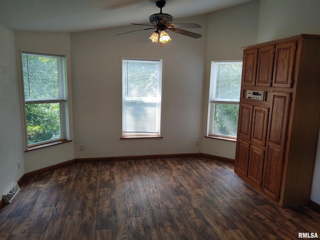 unfurnished dining area with ceiling fan, dark wood-type flooring, a healthy amount of sunlight, and lofted ceiling