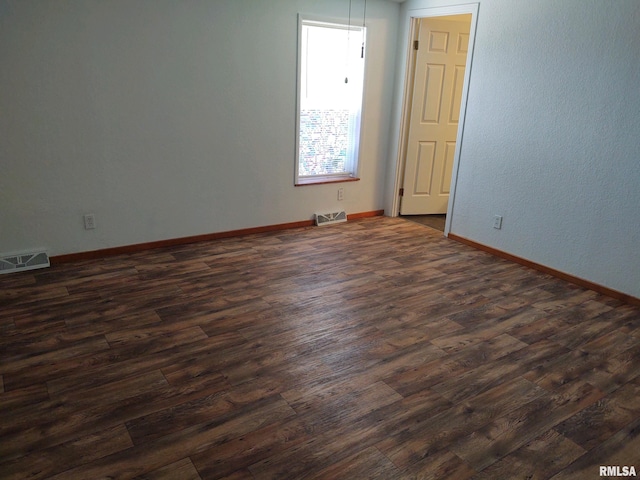 empty room featuring dark hardwood / wood-style flooring