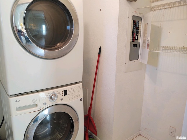 laundry room featuring stacked washer and dryer and electric panel