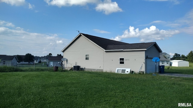 view of home's exterior featuring a garage, cooling unit, a lawn, and fence