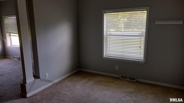 carpeted empty room featuring baseboards and visible vents