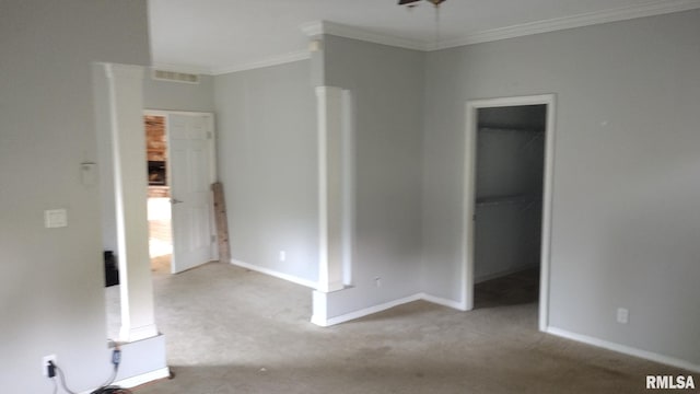 unfurnished bedroom featuring carpet flooring, a walk in closet, visible vents, and crown molding