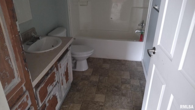 bathroom with toilet, stone finish flooring, bathing tub / shower combination, and vanity