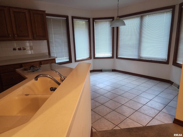 kitchen featuring pendant lighting, light tile patterned floors, and a healthy amount of sunlight