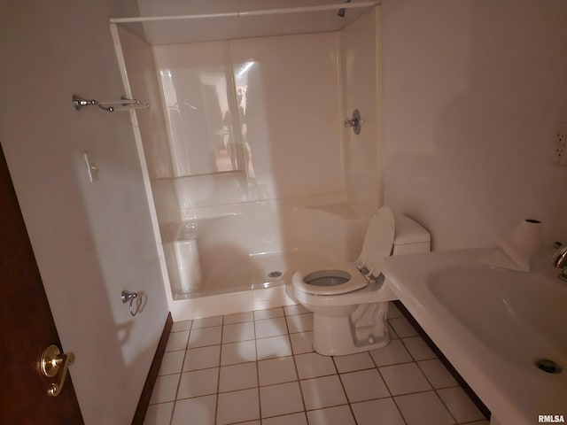 bathroom featuring walk in shower, toilet, sink, and tile patterned floors