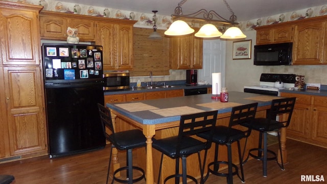 805 W Race St, Ridgway, IL 62979 - kitchen featuring hanging light fixtures, a center island, sink, dark hardwood / wood-style floors, and black appliances