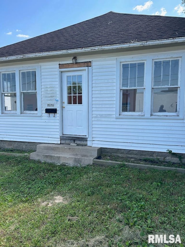 view of exterior entry with a yard