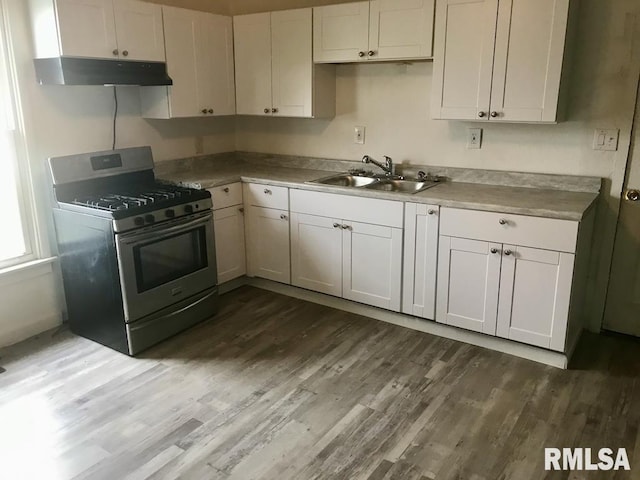 kitchen featuring white cabinets, sink, stainless steel gas stove, and dark hardwood / wood-style floors