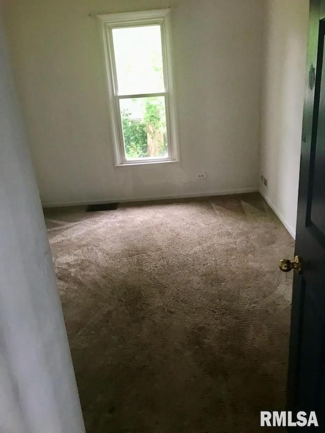 spare room featuring dark carpet