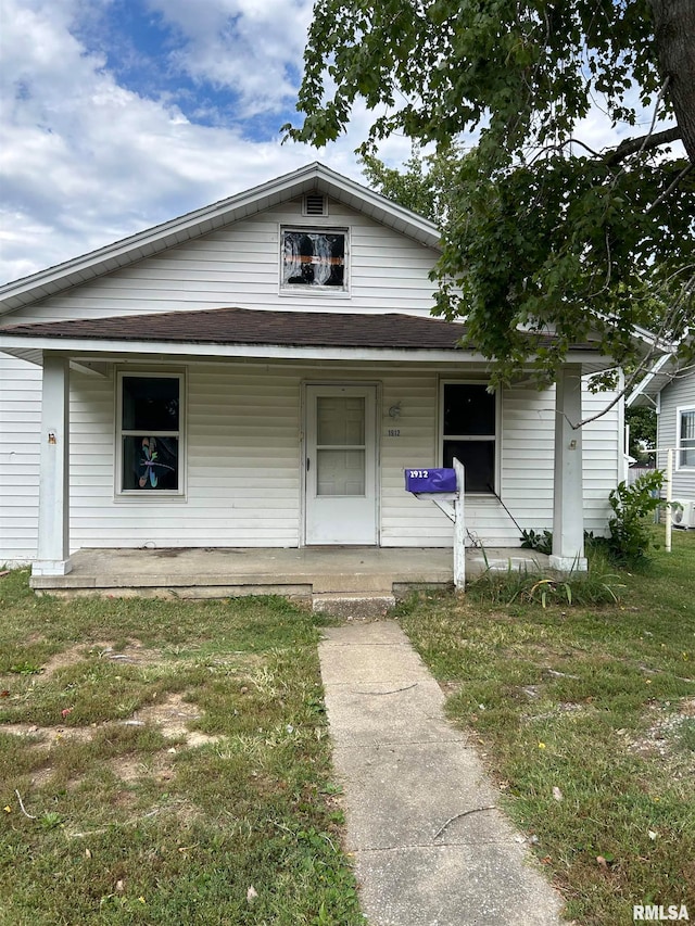 view of front facade featuring a front yard and covered porch