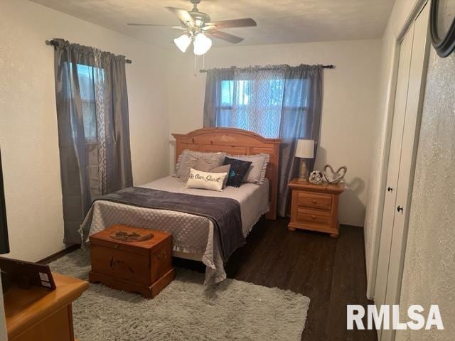 bedroom with dark hardwood / wood-style flooring and ceiling fan