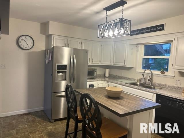 kitchen with hanging light fixtures, a breakfast bar, stainless steel refrigerator with ice dispenser, white cabinetry, and dishwasher