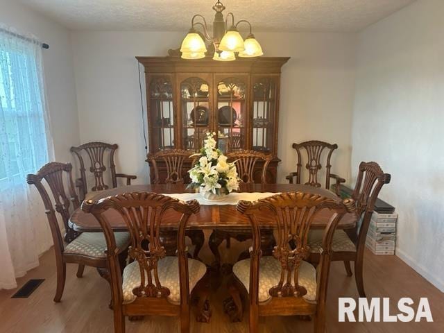 dining room featuring hardwood / wood-style flooring and an inviting chandelier