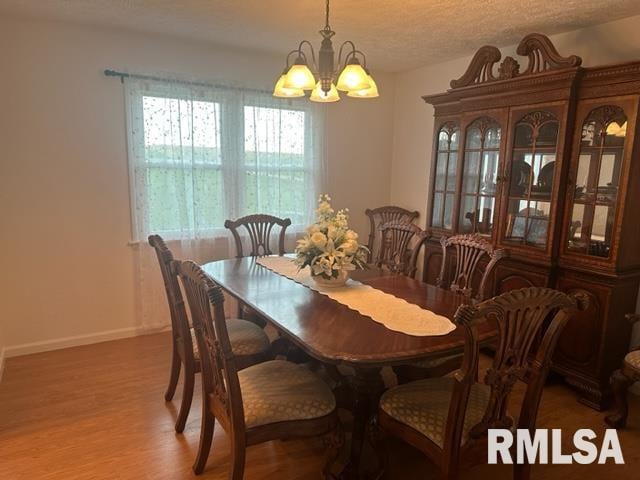 dining room featuring an inviting chandelier, dark hardwood / wood-style floors, and a textured ceiling