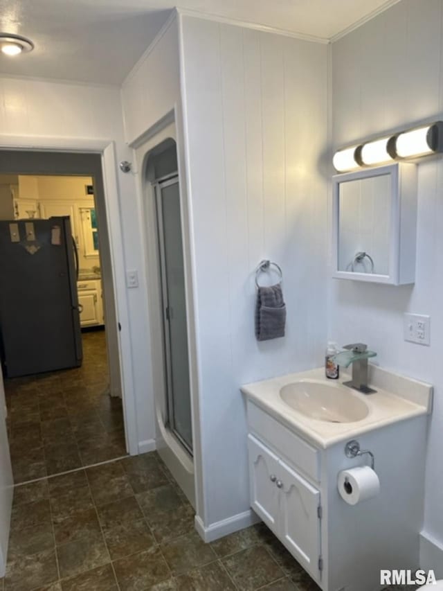 bathroom featuring a shower with door, tile floors, and vanity