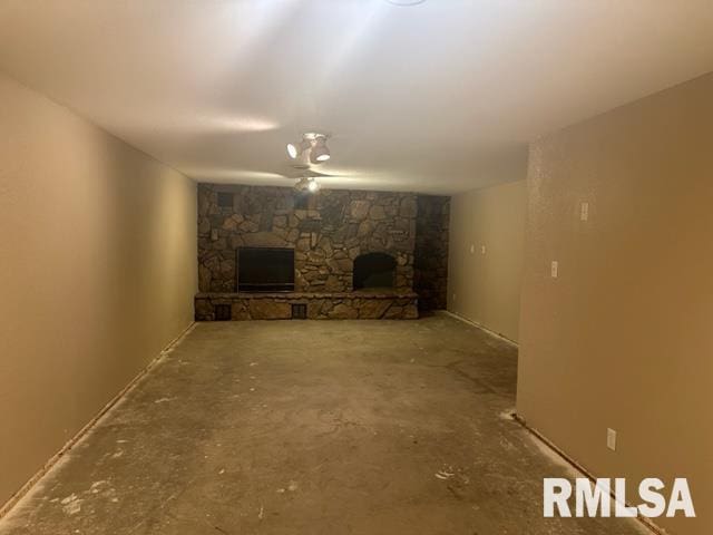 unfurnished living room with concrete flooring and a fireplace