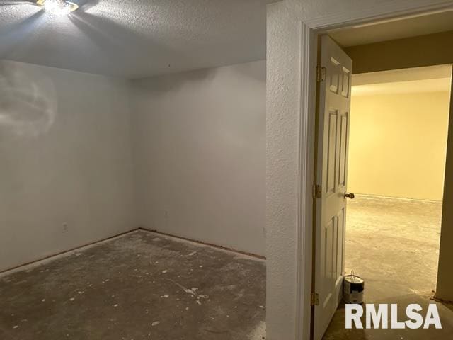 unfurnished room with concrete flooring and a textured ceiling